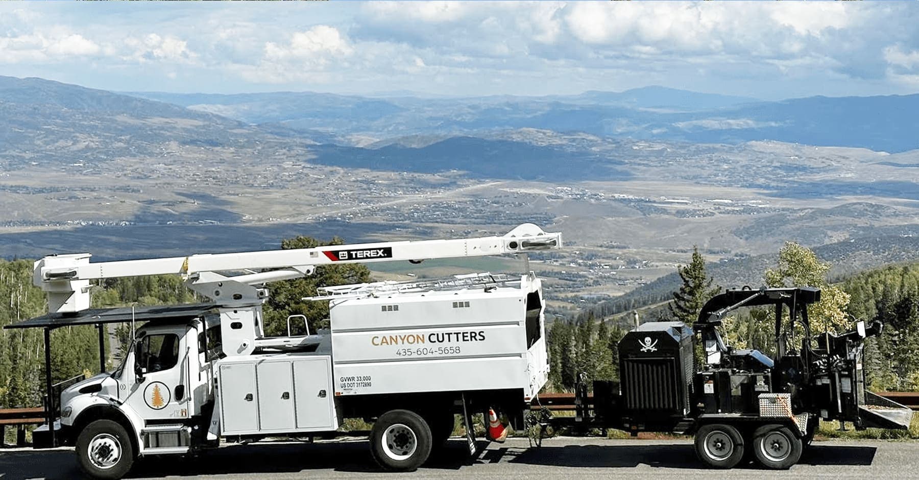 Canyon Cutters bucket truck and chipper staged on a Park City overlook
